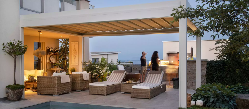 Pérgola bioclimática blanca con lamas y muebles de jardin