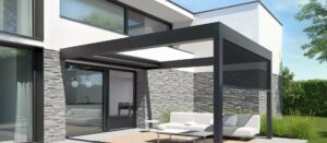 Pérgola bioclimática negra en jardin con sofa y mesa
