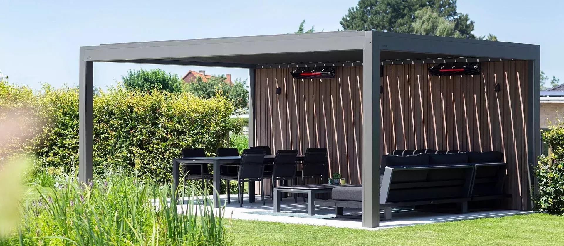 Pérgola bioclimática con lamas motor, y muebles de jardín